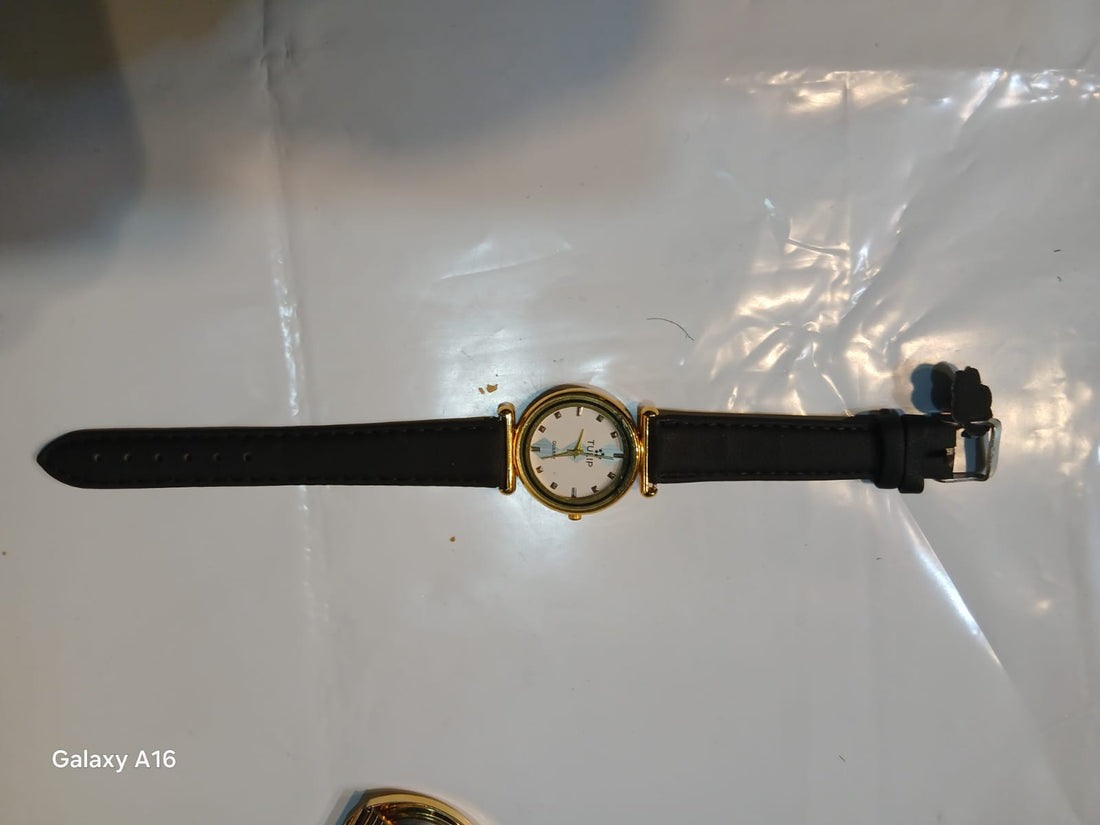 Unisex analog wristwatch with leather strap and gold-tone case.